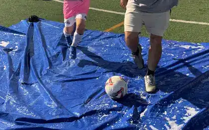 Niños jugando con una lona de agua en una actividad de verano de INTTACTIC